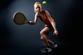 Beautiful woman playing padel indoor. Isolated on black.