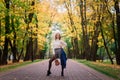 Beautiful woman playing ukulele guitar at outdoor in autumn forest