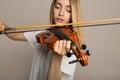 Beautiful woman playing violin on beige background, closeup Royalty Free Stock Photo