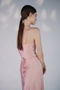 Beautiful woman pose in studio in pink classic dress