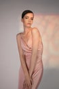 Beautiful woman pose in studio in pink classic dress