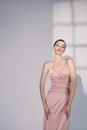 Beautiful woman pose in studio in pink classic dress