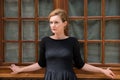 Beautiful woman posing on a background of the old wooden window.