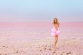 Beautiful woman with baloons on pink salt lake