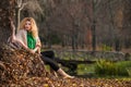 Beautiful woman posing in park during autumn season. Blonde girl wearing green blouse and big shawl posing outdoor. Long fair hair Royalty Free Stock Photo