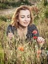 Beautiful woman posing in poppy flowers field, beauty, fashion a Royalty Free Stock Photo