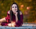 Beautiful woman posing sitting ground in autumn park