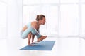 Beautiful woman practices handstand yoga asana Bhuja Pidasana - Arm pressure pose at the yoga studio Royalty Free Stock Photo