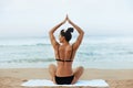 Beautiful woman practices yoga and meditates in the lotus position on th ebeach. Royalty Free Stock Photo