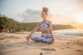 Beautiful woman practicing yoga on the beach. Sitting in Padmasana, Lotus Pose. Hands in gyan mudra. Closed eyes. Positive energy Royalty Free Stock Photo