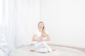 Beautiful woman is practicing yoga at home, girl doing Gomukasana exercise, sitting in Cow Face pose Royalty Free Stock Photo