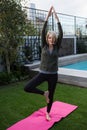 Beautiful woman practicing yoga in lawn Royalty Free Stock Photo