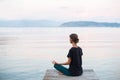 Beautiful woman practicing yoga near the sea, Young girl meditate at sunset on the beach. Royalty Free Stock Photo