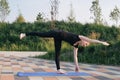 beautiful woman practising yoga in a city park