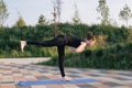 Beautiful woman practising yoga in a city park