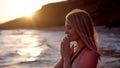 Beautiful woman prays on the sea shore on the sunset Royalty Free Stock Photo