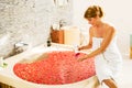 Woman preparing romantic bath with flowers and using bathing product Royalty Free Stock Photo