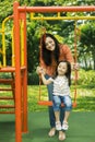 Beautiful woman pushing her child on the swing Royalty Free Stock Photo