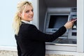 Beautiful woman put her credit card at the ATM