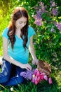 Beautiful woman puts flowers in the basket Royalty Free Stock Photo