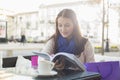 Beautiful woman reading book at sidewalk cafe Royalty Free Stock Photo