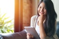 Beautiful woman reading a magazine online on tablet at coffee cafe Royalty Free Stock Photo