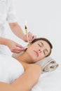 Beautiful woman receiving ear candle treatment at spa center Royalty Free Stock Photo