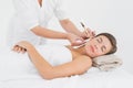 Beautiful woman receiving ear candle treatment at spa center Royalty Free Stock Photo