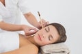 Beautiful woman receiving ear candle treatment at spa center Royalty Free Stock Photo