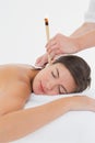 Beautiful woman receiving ear candle treatment at spa center Royalty Free Stock Photo