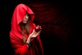 Beautiful woman with red cloak holding apple