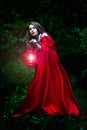 Beautiful woman with red cloak and lantern in the woods Royalty Free Stock Photo