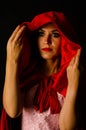 beautiful woman red cloak with red flowers roses in studio. Woman Red Riding Hood. Dramatic and fantastic shooting Royalty Free Stock Photo