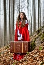 Beautiful woman with red cloak and suitcase