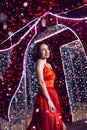 Beautiful woman in red dress in christmas decor background beauty portrait photoshoot Royalty Free Stock Photo