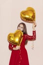 Woman holds heart shaped golden air balloons. valentines day, birthday, womens day, anniversary, holiday celebration concept Royalty Free Stock Photo