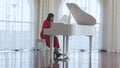 Beautiful woman plays a white piano