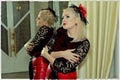 The beautiful woman in a red dress and a red hat at a mirror Royalty Free Stock Photo