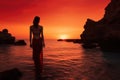 Beautiful woman in red dress standing in the sea at sunset, Epic red sunset in Cala Llentrisca with model , Ibiza, AI Generated Royalty Free Stock Photo