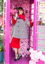 A beautiful woman in a red dress is talking on the phone in a phone booth. Royalty Free Stock Photo