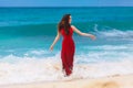 Beautiful woman in a red dress on the tropical sea coast Royalty Free Stock Photo