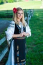 Beautiful woman with red flower in her hair posing in Romanian t Royalty Free Stock Photo