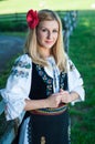 Beautiful woman with red flower in her hair posing in Romanian t Royalty Free Stock Photo