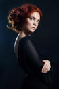 Beautiful woman with red hair on a black background. Portrait of a successful woman, pure skin, natural makeup, skin care face Royalty Free Stock Photo