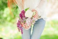 Beautiful woman with red hair holding white and violet lilac bloom in her hands, outdoor garden Royalty Free Stock Photo