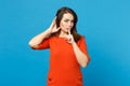 Beautiful woman in red orange dress saying hush be quiet with finger on lips shhh gesture isolated over trendy blue