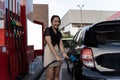 Beautiful woman refueling car. Attractive young woman refueling car at gas station. Female filling diesel at gasoline fuel in car Royalty Free Stock Photo