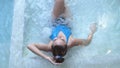 Top of view of beautiful young woman relaxes in a hydromassage jacuzzi, in swimming pool. Concept: spa procedures, body Royalty Free Stock Photo