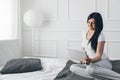 Beautiful woman relaxing on the bed and using her tablet Royalty Free Stock Photo