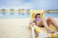 Beautiful Woman relaxing in a lounge chair on a tropical beach vacation Royalty Free Stock Photo